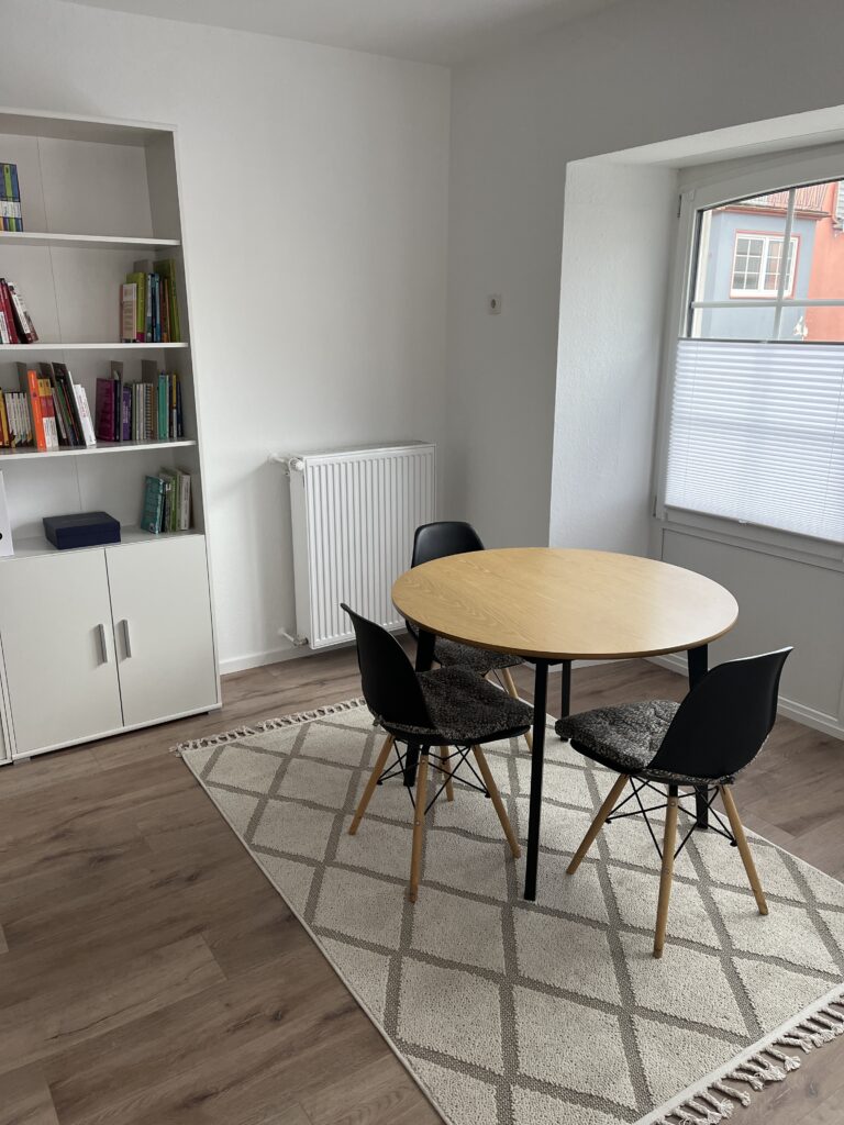 Ruhiger Gesprächsraum mit rundem Tisch und Stühlen in der Lerntherapie-Praxis, Ort für Elterngespräche